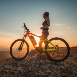 vrouw met e-mtb op bergtop